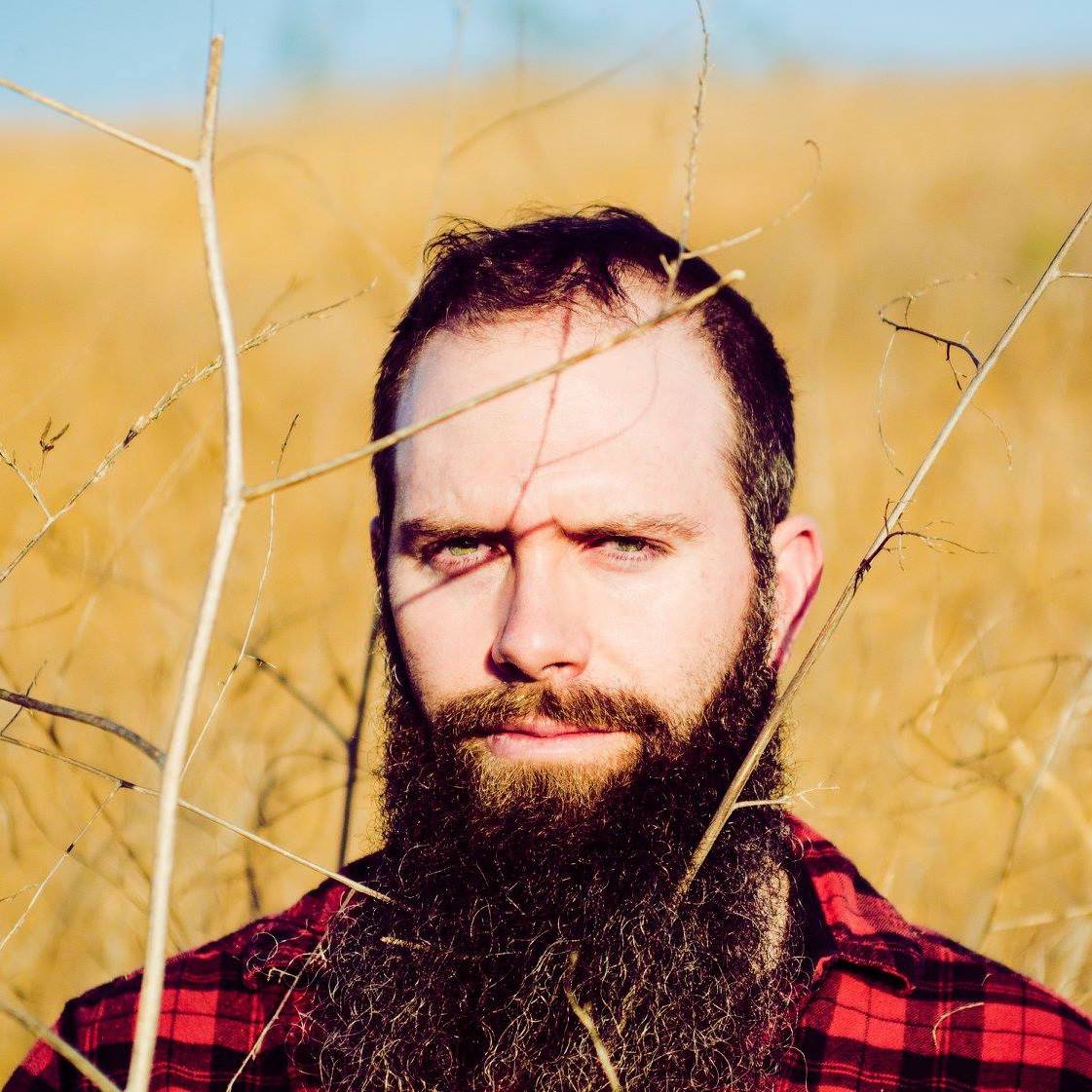 Image of a the author as a bearded hipster in tall grass.