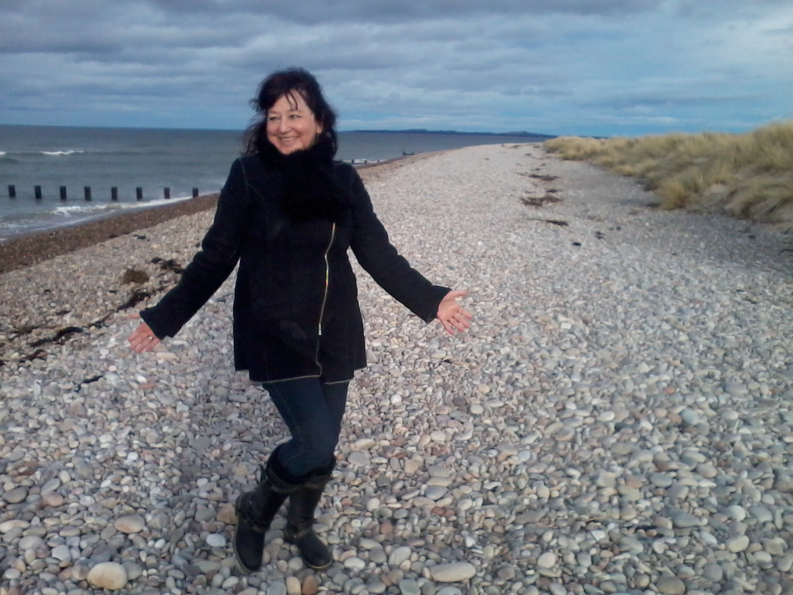 Kerrie Noor celebrating a story finished on a beach in Scotland