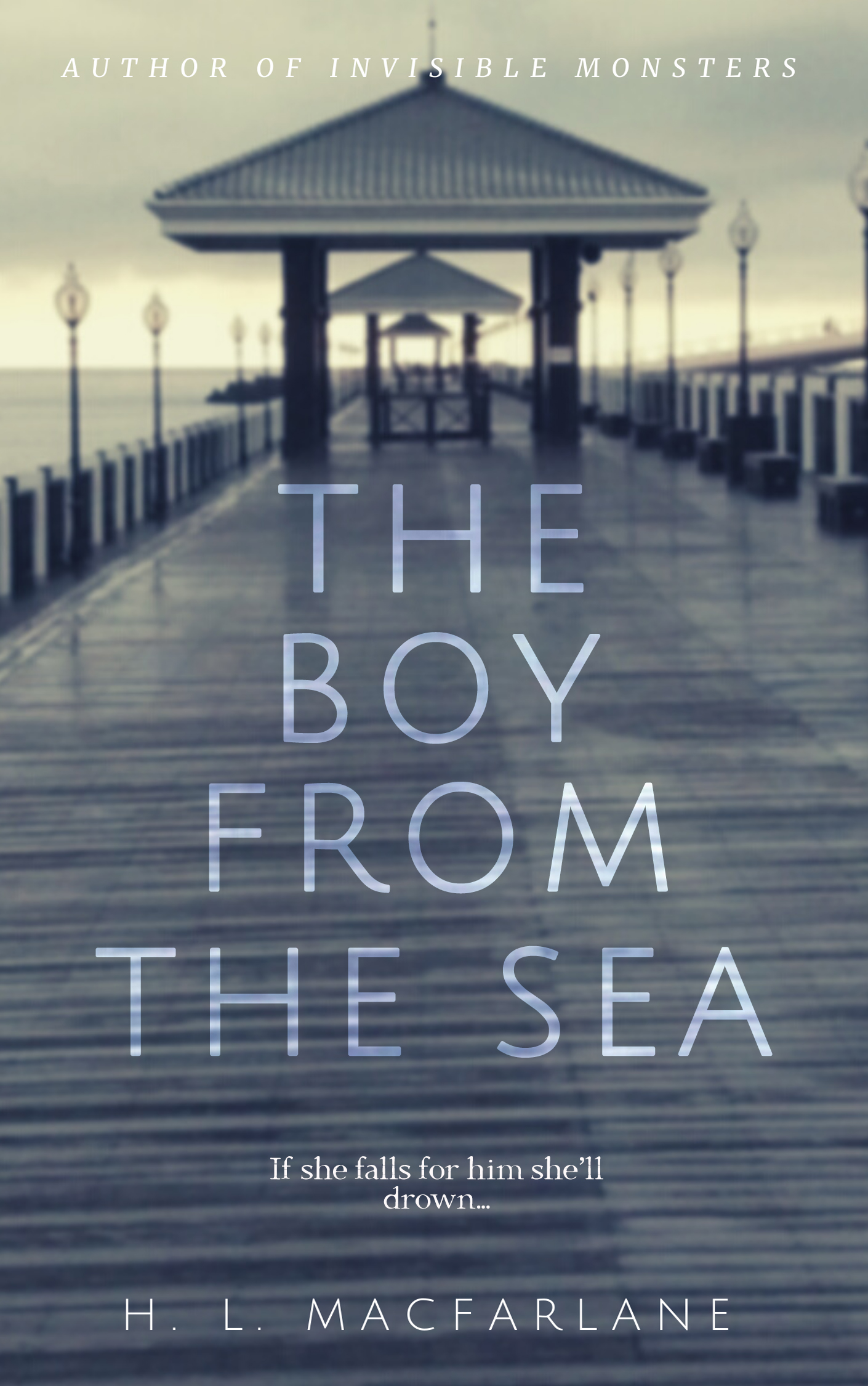 The title 'The Boy from the Sea' is written in capital letter, sans serif font in transluscent white letters across a faded, wet blue pier with pale yellow clouds. 