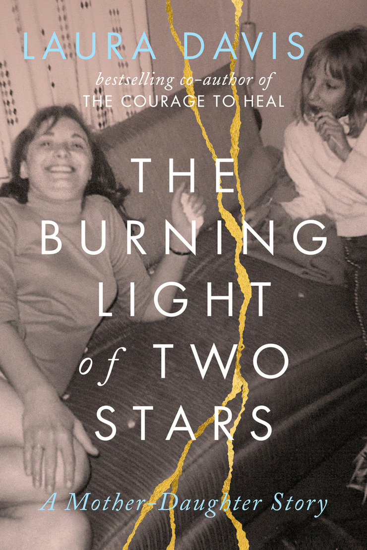 This is my book cover. It shows an older photo from the sixties of a mother relaxing on a couch looking at the camera with a big smile while her young daughter looks over at her, a pensive look on her face. The title of the book, The Burning Light of Two Stars: A Mother Daughter Story is broken up by gold lines, like tears running across the page. The words Laura Davis, bestselling author of The Courage to Heal run across the top.