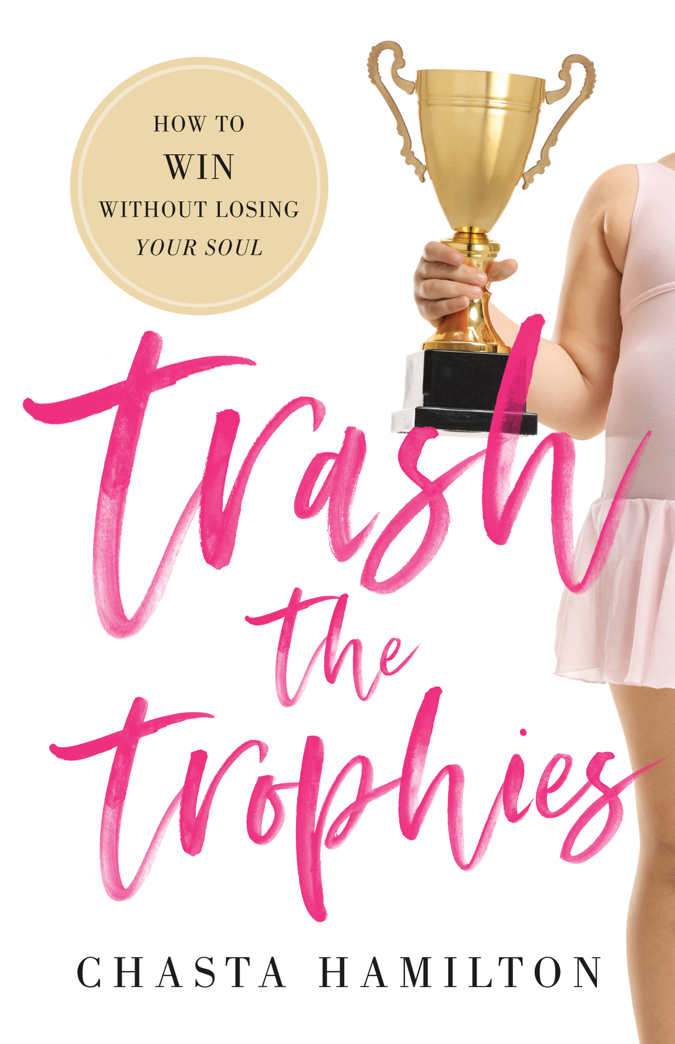 a white background features a dancer in a pink leotard with attached skirt holds a large trophy. a scribbled font says trash the trophies in hot pink. a medallion in the upper lefthand corner holds the tagline: "how to WIN without losing your soul" the bottom of the cover holds the author's name: chasta hamilton. 