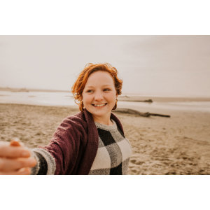 Jessica Bird on the beach in purple scarf and black and white checkered sweater