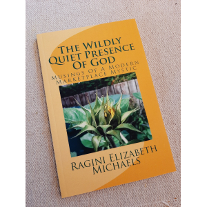 image of book cover composed of title, sub-title, and picture of yellow spring bud just opening out of green leaves that were protecting it amidst the plants green foliage. The background is two shades of yello with a swirling design - title Is The Wildly Quiet Presence Of God. Sub-title is Musings of a Modern Marketplace Mystic. Author's name is Ragini Elizabeeth Michaels